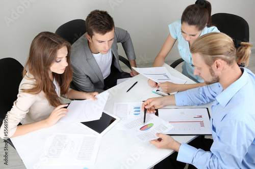 Photo: Business team working on their project together at office Business team working on their project together at office