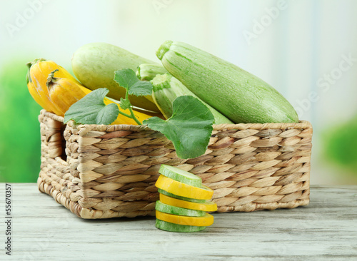 Photo: Sliced and whole raw zucchini in wicker crate, outdoors Sliced and whole raw zucchini in wicker crate, outdoors