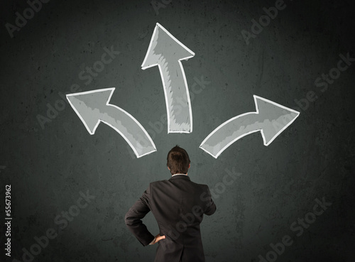 Photo: Businessman deciding with arrows above his head Businessman deciding with arrows above his head