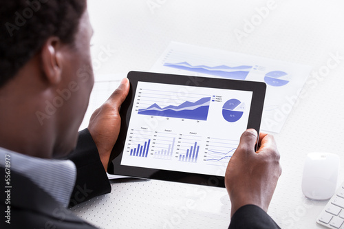 Photo: Businessman Looking At Digital Tablet Businessman Looking At Digital Tablet