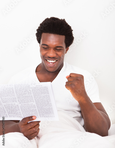Photo: Young African Man Reading Newspaper Young African Man Reading Newspaper