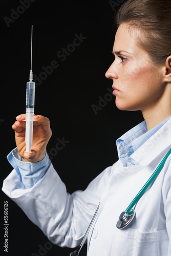 Photo: Doctor woman with syringe on black background Doctor woman with syringe on black background
