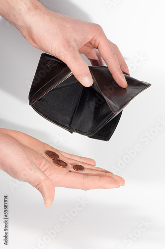 Photo: Man hands holding an empty wallet and some euro coins Man hands holding an empty wallet and some euro coins