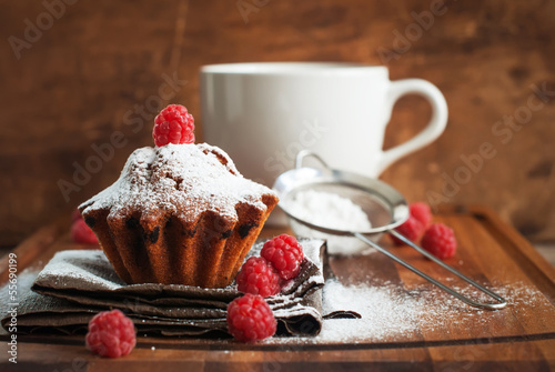 Photo: Fruitcake Decorated with Raspberry and icing sugar at the wooden Fruitcake Decorated with Raspberry and icing sugar at the wooden