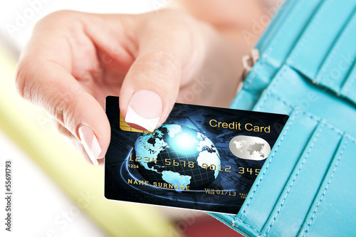 Photo: credit card in woman's hand taken out from wallet credit card in woman's hand taken out from wallet
