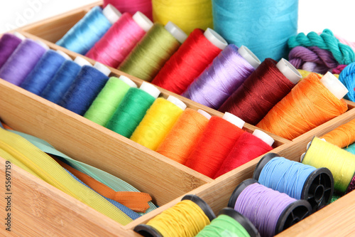 Photo: Sewing accessories in wooden box close up Sewing accessories in wooden box close up