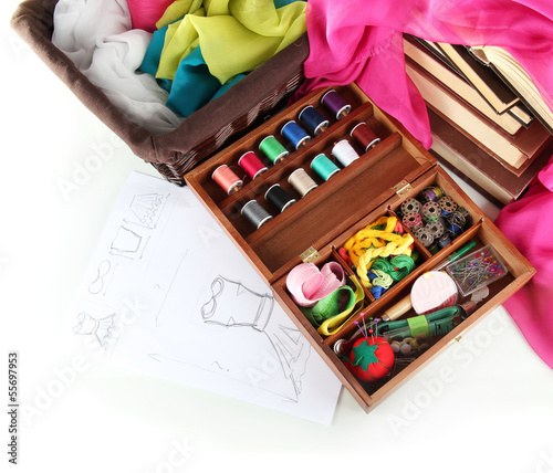 Photo: Sewing kit in wooden box with books and cloth isolated on white Sewing kit in wooden box with books and cloth isolated on white