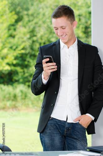 Photo: geschäftsmann schaut auf sein handy geschäftsmann schaut auf sein handy