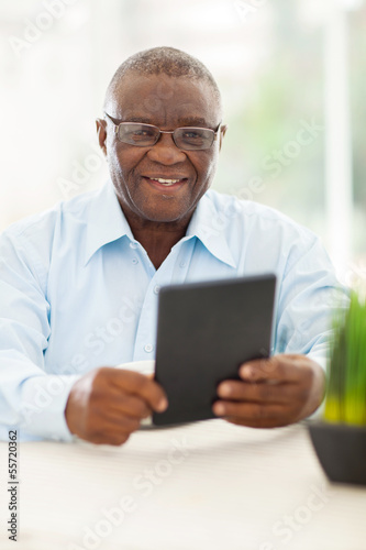 Photo: senior african man holding tablet computer senior african man holding tablet computer