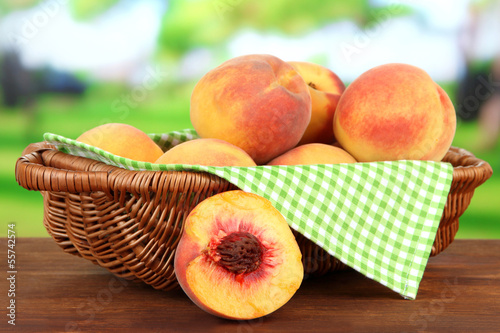 Photo: Ripe sweet peaches in wicker basket, on bright background Ripe sweet peaches in wicker basket, on bright background