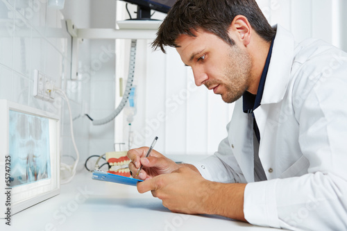 Photo: Dentist with x-ray image taking notes Dentist with x-ray image taking notes