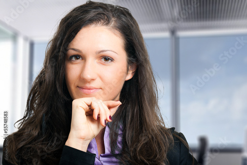 Photo: Smiling businesswoman in her office Smiling businesswoman in her office