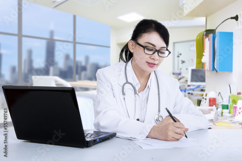 Photo: Beautiful doctor write prescription at clinic Beautiful doctor write prescription at clinic
