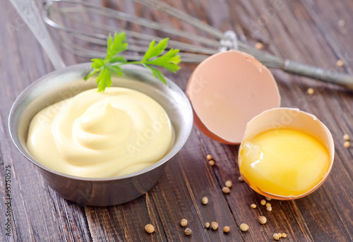 Photo: mayonnaise in metal spoon on wooden board mayonnaise in metal spoon on wooden board