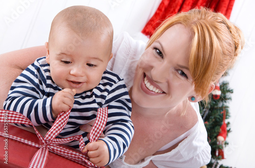Photo: Mutter und Sohn packen ein Geschenk zu Weihnachten aus Mutter und Sohn packen ein Geschenk zu Weihnachten aus