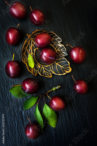 Photo: Ripe plums on a black slate chalkboard Ripe plums on a black slate chalkboard