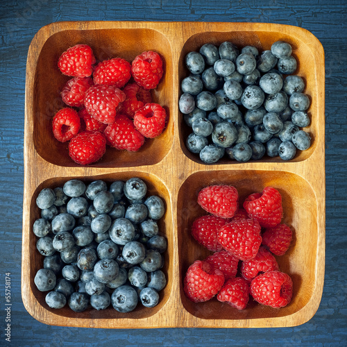 Photo: Raspberries and blueberries in a wooden bowl Raspberries and blueberries in a wooden bowl