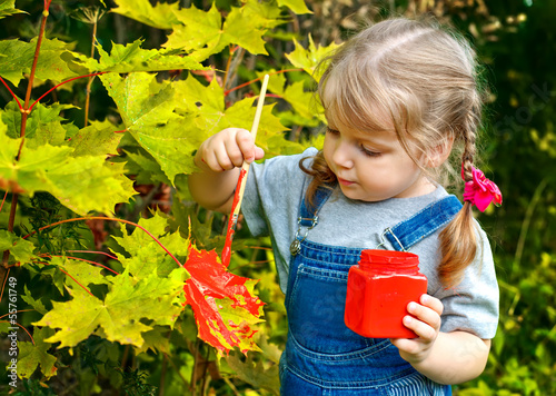 Photo: little girl paint colors on the leaves of the tree little girl paint colors on the leaves of the tree