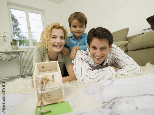 Photo: Junge Familie im Wohnzimmer, lächelnd, Porträt Junge Familie im Wohnzimmer, lächelnd, Porträt