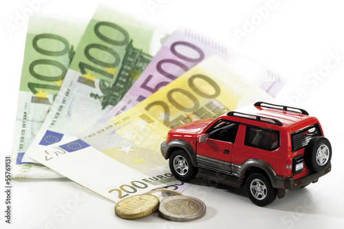 Photo: Spielzeugauto auf Euro-Banknoten und-Münzen, Nahaufnahme Spielzeugauto auf Euro-Banknoten und-Münzen, Nahaufnahme