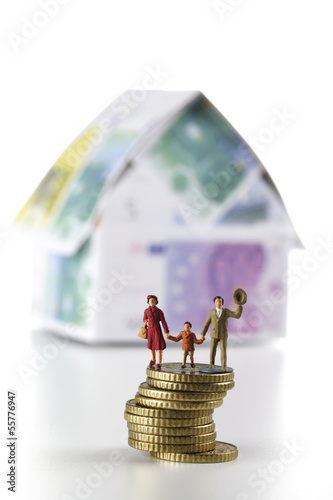 Photo: Figuren auf Münzen vor dem Haus aus Euro-Banknoten Figuren auf Münzen vor dem Haus aus Euro-Banknoten