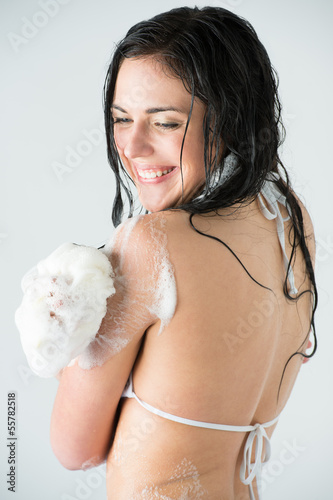 Photo: Young woman washing body with shower gel Young woman washing body with shower gel