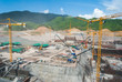 Huge construction site for dam with cranes in mountain area Huge construction site for dam with cranes in mountain area