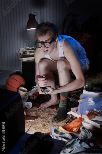 Photo: Gamer nerd playing video games on television Gamer nerd playing video games on television