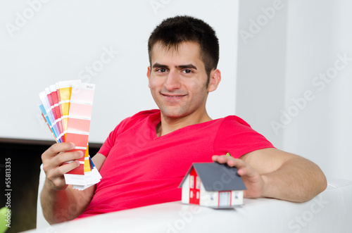 Photo: junger mann mit haus und farbkarten junger mann mit haus und farbkarten