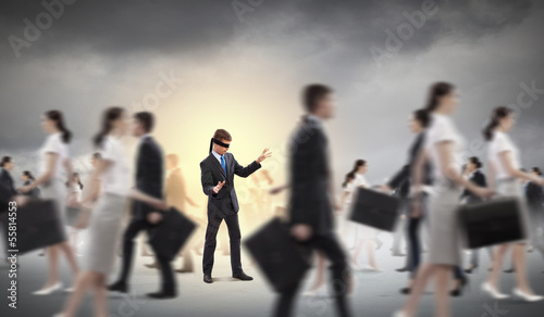 Photo: Businessman in blindfold among group of people Businessman in blindfold among group of people