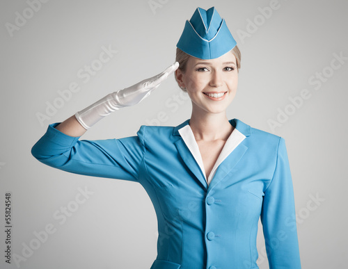 Photo: Charming Stewardess Dressed In Blue Uniform On Gray Background Charming Stewardess Dressed In Blue Uniform On Gray Background
