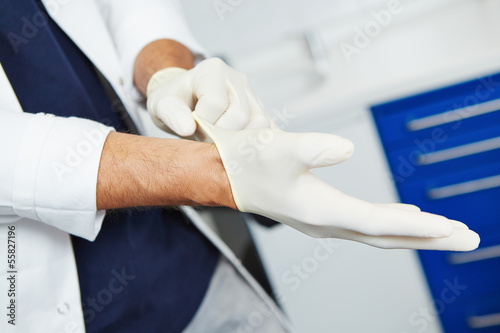 Photo: Dentist putting on gloves Dentist putting on gloves