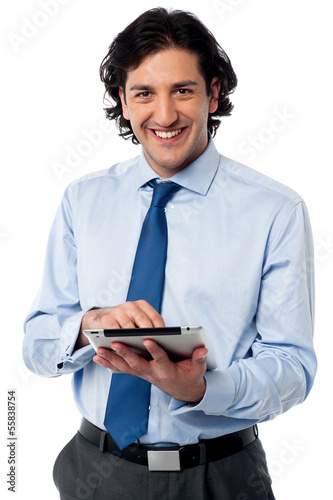 Photo: Young businessman operating tablet device Young businessman operating tablet device