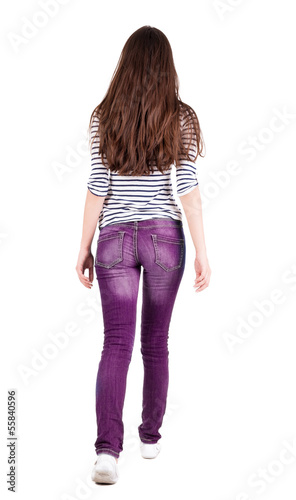 Photo: back view of walking woman in jeans . back view of walking woman in jeans .