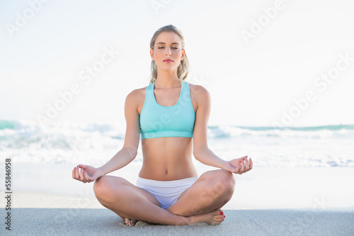 Photo: Relaxed slender blonde in sportswear meditating Relaxed slender blonde in sportswear meditating
