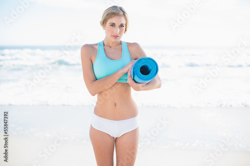 Photo: Charming blonde woman in sportswear carrying an exercise mat Charming blonde woman in sportswear carrying an exercise mat
