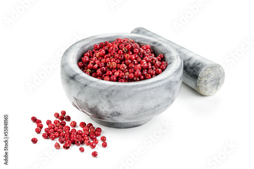Photo: Pink pepper with mortar and pestle on white background Pink pepper with mortar and pestle on white background