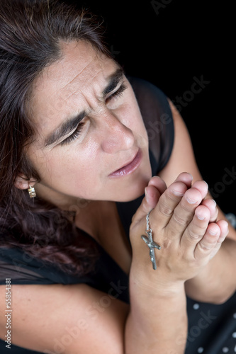 Photo: Dramatic portrait of an hispanic woman praying Dramatic portrait of an hispanic woman praying