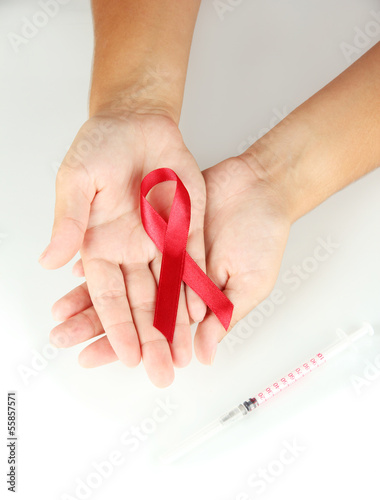 Photo: AIDS ribbon in hands isolated on white AIDS ribbon in hands isolated on white