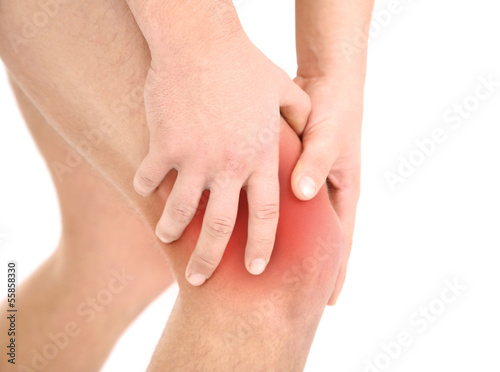 Photo: Young man with knee pain, isolated on white Young man with knee pain, isolated on white