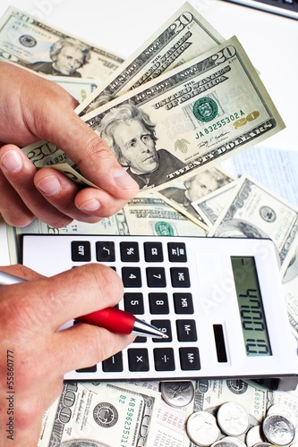 Photo: Hand with calculator and money. Hand with calculator and money.