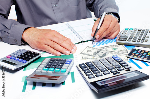 Photo: Hand with calculator and money. Hand with calculator and money.