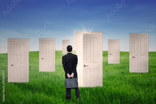 Photo: Businessman standing in front of opportunity door Businessman standing in front of opportunity door