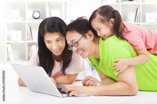 Photo: happy family with child looking at laptop happy family with child looking at laptop