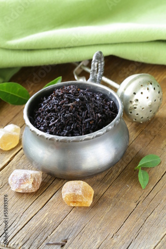Photo: granulated black tea in a metal cup on a wooden table granulated black tea in a metal cup on a wooden table
