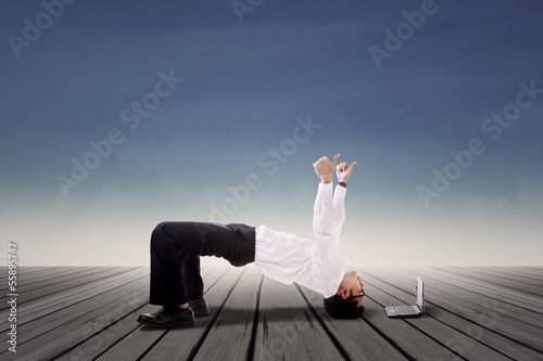 Photo: Businessman doing bridge yoga outdoor Businessman doing bridge yoga outdoor