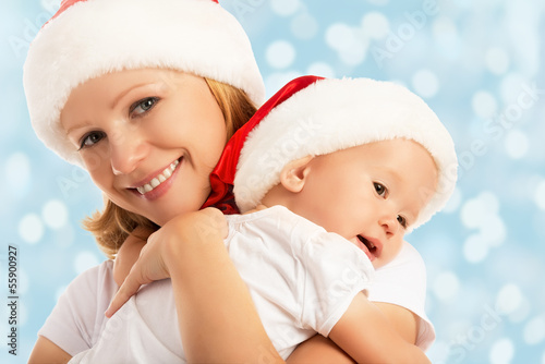 Photo: happy family mother and baby in Christmas hats happy family mother and baby in Christmas hats
