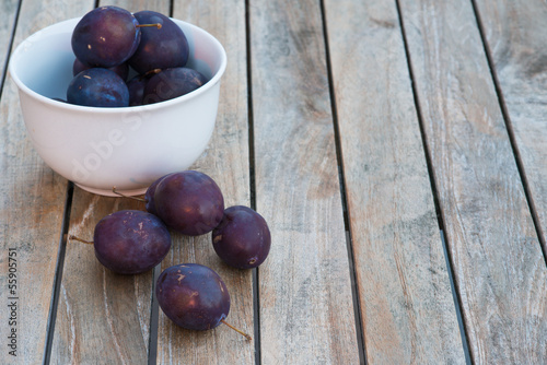 Photo: Arrangement of damson plums on wooden boards Arrangement of damson plums on wooden boards