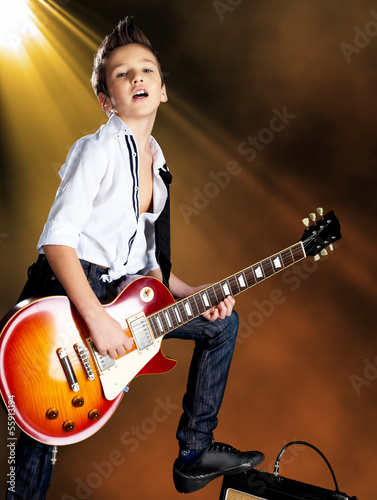 Photo: Boy playing on electric guitar on the stage Boy playing on electric guitar on the stage