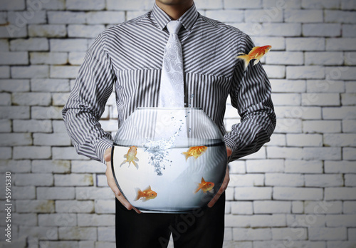 Photo: Business man flying goldfishes Business man flying goldfishes
